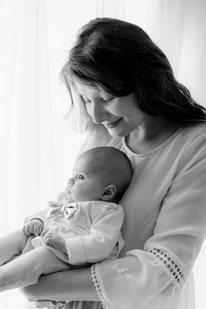 Une maman et son bébé dans les bras photographie en noir et blanc